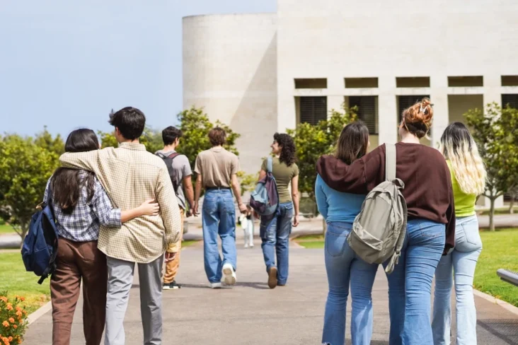 Imagem de estudantes universitários na entrada do instituto de ensino