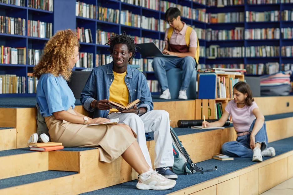 Os estudantes não bolseiros também podem receber apoios? Imagem de estudantes universitários na biblioteca do campus