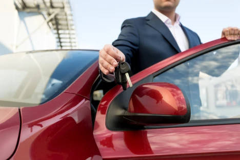 Os 7 erros mais comuns ao contratar um renting Fotografia de um homem num carro alugado