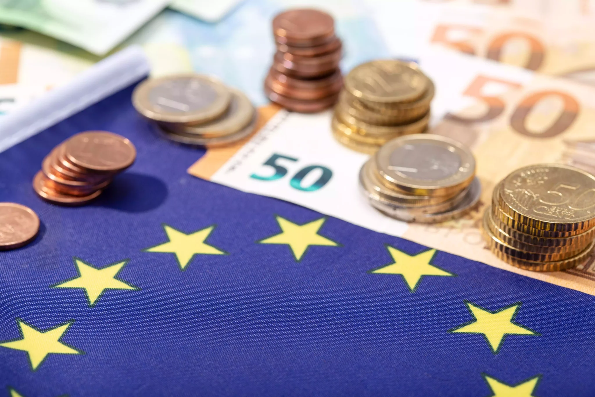 Moedas de euro sobre bandeira da União Europeia