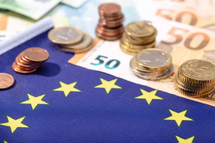 Moedas de euro sobre bandeira da União Europeia