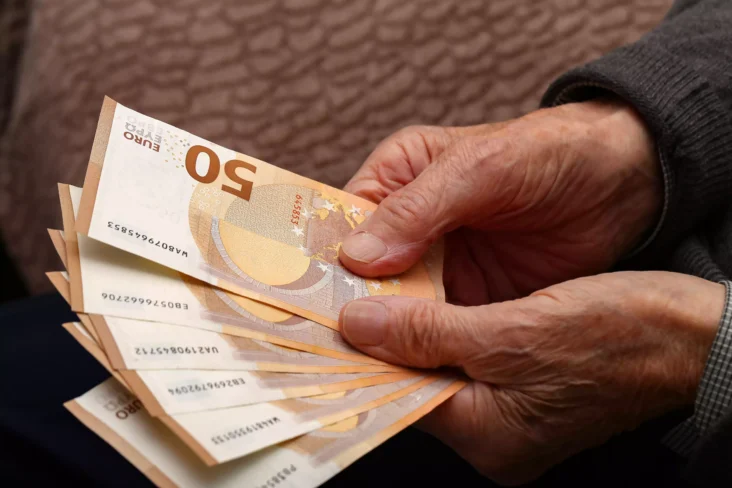 Idoso a segurar notas de euro