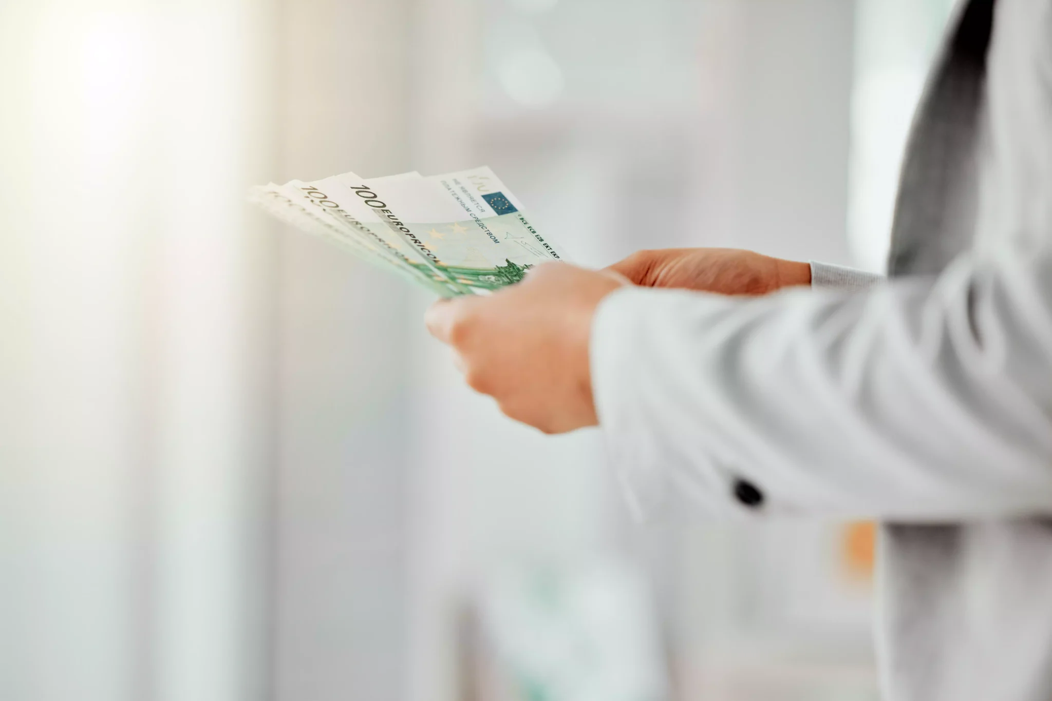 Salários recuperam em Portugal, mas há mais horários fora do habitual Homem a segurar notas de euro