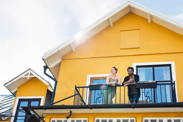 Imagem de um casal na varanda de uma moradia