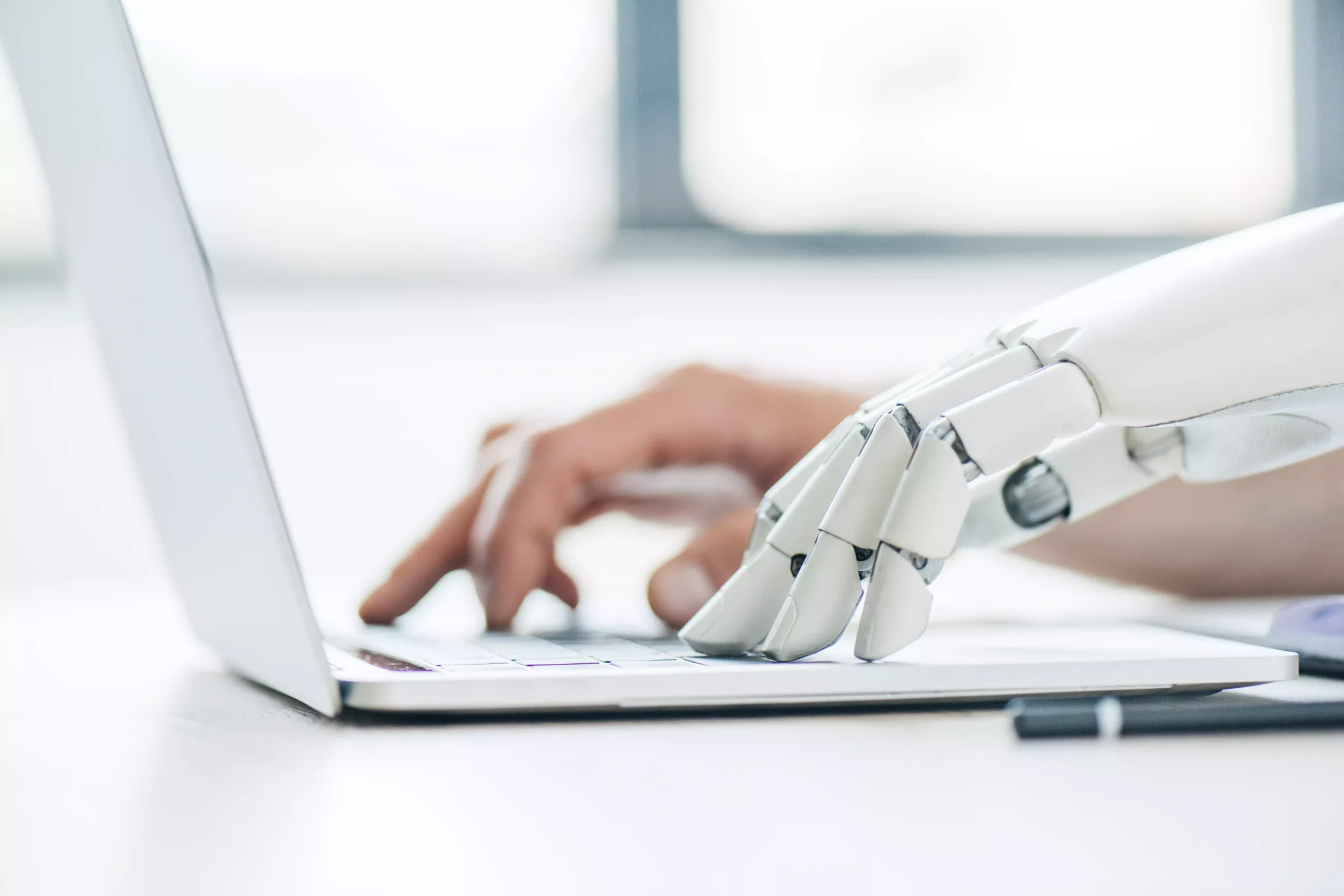 Mão humana e mão de robô no computador