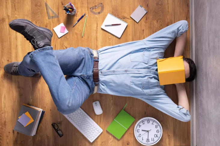 Homem a relaxar no chão com livro na cabeça